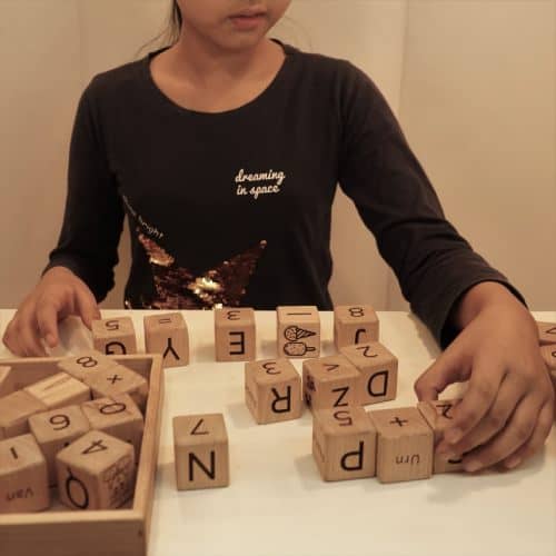 girl playing alphabets with numbers wooden blocks toy