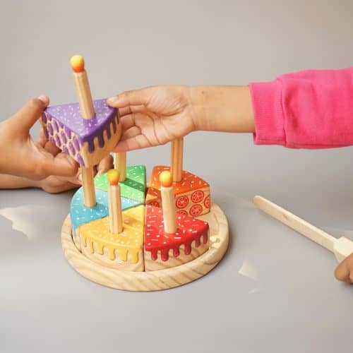 girl playing with cutting wooden cake toy