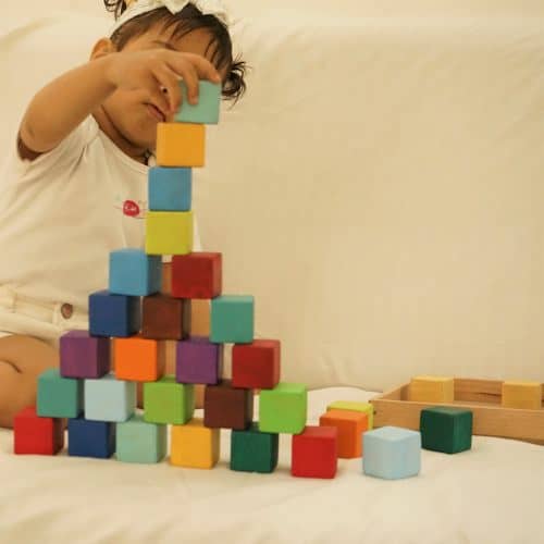baby playing with colorful wooden blocks toy