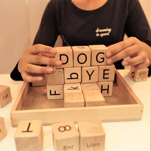 girl playing with alphabets wooden blocks toy