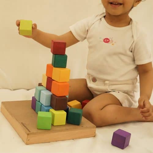 baby playing with colorful wood blocks set toy